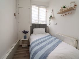 A bedroom with a single bed and shelf at Driftwood in Rhyl