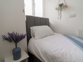 A bedroom with a bed and a plant at Driftwood in Rhyl