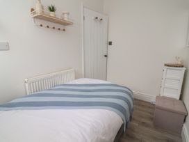 A bedroom with a bed and shelf at Driftwood in Rhyl