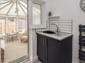 A kitchen area with a sink and cabinets at Driftwood in Rhyl