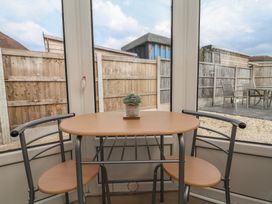 A conservatory with a table and chairs at Driftwood in Rhyl