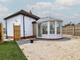 A conservatory attached to a house with gravel in the garden at Driftwood in Rhyl