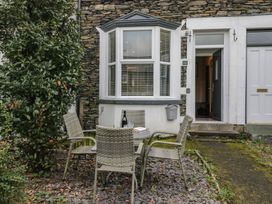 An outdoor seating area with a table and chairs at Highfield Cottage in Windermere