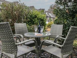A garden with chairs and a table at Highfield Cottage in Windermere
