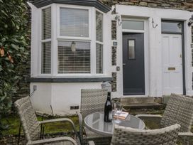 An outdoor seating area with a table and chairs at Highfield Cottage in Windermere