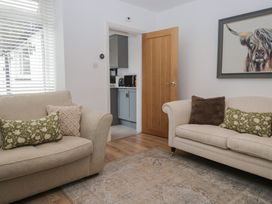 A living room with two sofas and a door leading to the kitchen at Highfield Cottage in Windermere