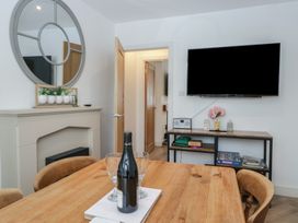 A dining room with a table and TV at Highfield Cottage in Windermere