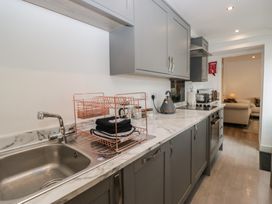 A kitchen with a sink, dish rack, and appliances at Highfield Cottage in Windermere