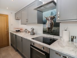 A kitchen with cabinets and stove at Highfield Cottage in Windermere