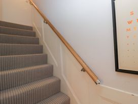 A staircase with carpet and handrail at Highfield Cottage in Windermere