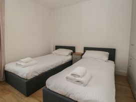 A bedroom with twin beds and a bedside table at Highfield Cottage in Windermere
