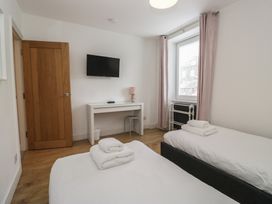 A bedroom with two beds and a desk at Highfield Cottage in Windermere