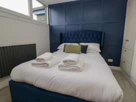 A bedroom with a blue bed and towels at Highfield Cottage in Windermere