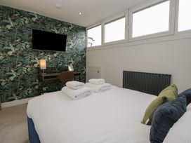 A bedroom with a bed and desk at Highfield Cottage in Windermere
