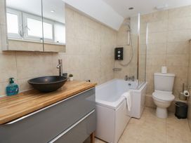 A bathroom featuring a bathtub, toilet, and modern sink at Highfield Cottage in Windermere