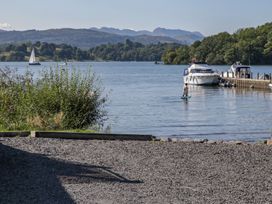 A view of a lake with a person on a paddleboard at Highfield Cottage in Windermere