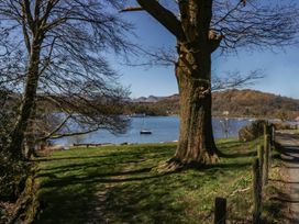 A view of a lake with a tree and a boat at Highfield Cottage in Windermere