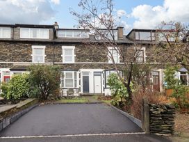 An outdoor area with a front door and shrubs at Highfield Cottage in Windermere