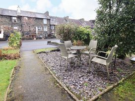 A garden area with a table and chairs at Highfield Cottage in Windermere