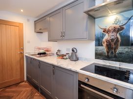 A kitchen with cabinets and a kettle at Highfield Cottage in Windermere