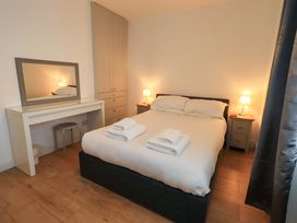 A bedroom with a bed and mirror at Highfield Cottage in Windermere