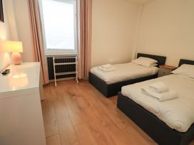 A bedroom with two beds and a window at Highfield Cottage in Windermere