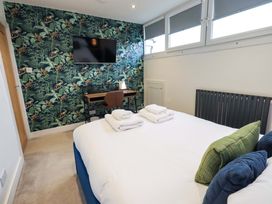 A bedroom with a bed and a desk at Highfield Cottage in Windermere
