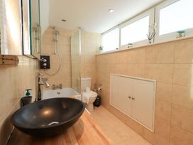 A bathroom with a sink, bathtub, shower, and toilet at Highfield Cottage in Windermere