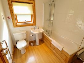 A bathroom with a toilet sink and bathtub with a shower at Forest Lodge in Kenwick Woods