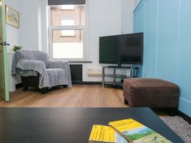 A living room with an armchair and television at Havelock Hideaway Windermere