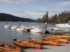 Various boats docked at a lake with trees and hills at Havelock Hideaway Windermere