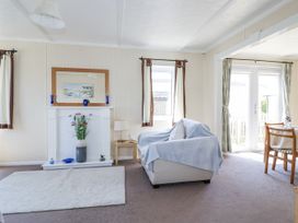 A living room with a sofa and fireplace at Lazy Days in St Merryn