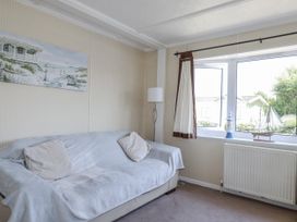 A living room with a sofa and window at Lazy Days in St Merryn