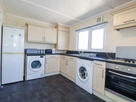 A kitchen with appliances and cabinets at Lazy Days St Merryn
