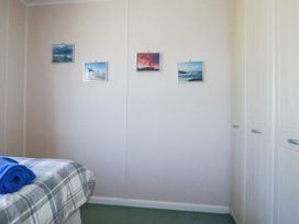 A bedroom with a bed and towels at Lazy Days in St Merryn