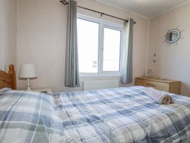 A bedroom with a bed and lamp at Lazy Days St Merryn