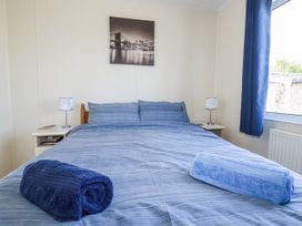 A bedroom with a bed and decorative wall art at Lazy Days in St Merryn