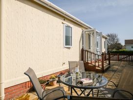 A patio area with a table and chairs at Lazy Days in St Merryn