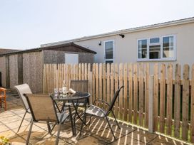 An outdoor seating area with a table and chairs at Lazy Days in St Merryn
