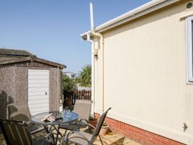 An outdoor seating area with a table and chairs at Lazy Days in St Merryn