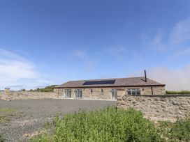 A stone building with solar panels and gravel area at West Burton Hemmel Bamburgh