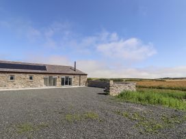 A stone building with solar panels and gravel area at West Burton Hemmel in Bamburgh