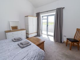 A bedroom with a bed and white furniture at West Burton Hemmel in Bamburgh