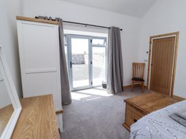 A bedroom with a bed and chair at West Burton Hemmel Bamburgh
