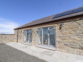 An outdoor area with stone walls and windows at West Burton Hemmel in Bamburgh