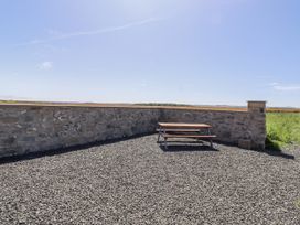 An outdoor area with a picnic table and a stone wall at West Burton Hemmel Bamburgh