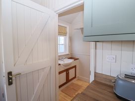 A kitchen counter with a toaster and a view into a small room with a sink under a window at The Woodshed in Tendring near Weeley