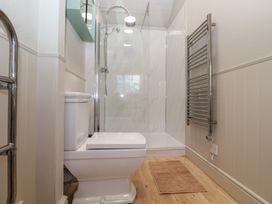 A bathroom with a toilet a walk-in shower and a wall-mounted towel radiator at The Woodshed in Tendring near Weeley