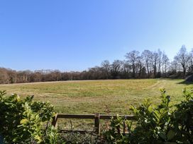 A field with grass and trees in the background at The Woodshed in Tendring near Weeley