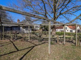 An outdoor garden area with wooden and wire fencing and trees near houses at The Woodshed in Tendring near Weeley